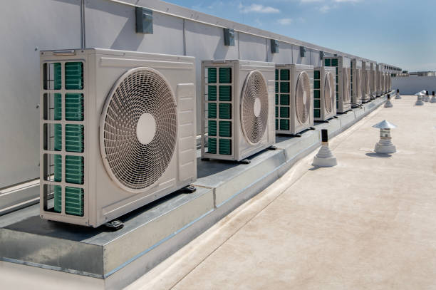 long row of air conditioner units on a membrane roof. long row of air conditioner units on a membrane roof.